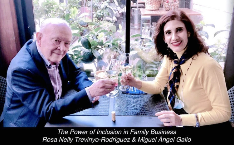 Two individuals sitting at a table, clinking glasses in celebration, surrounded by a bright indoor setting filled with plants.