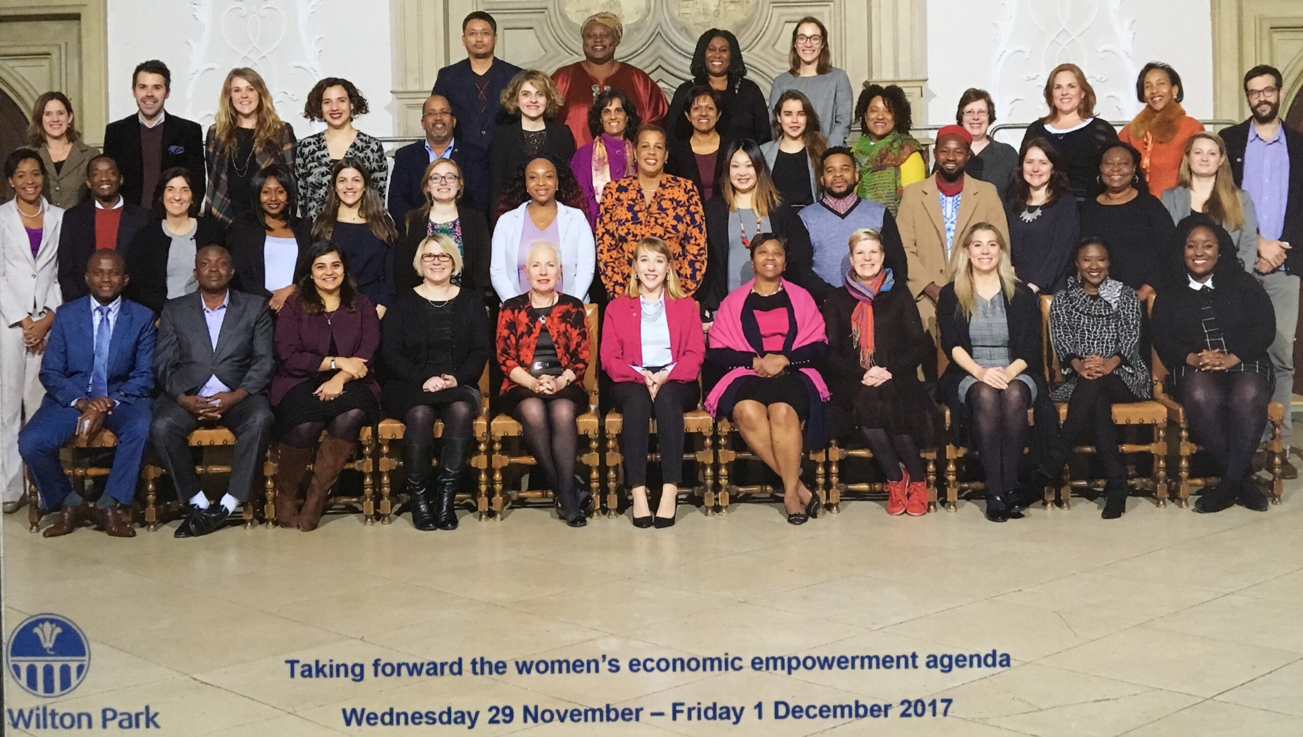 A diverse group of individuals posing together in an indoor setting, focusing on women's economic empowerment and collaboration.