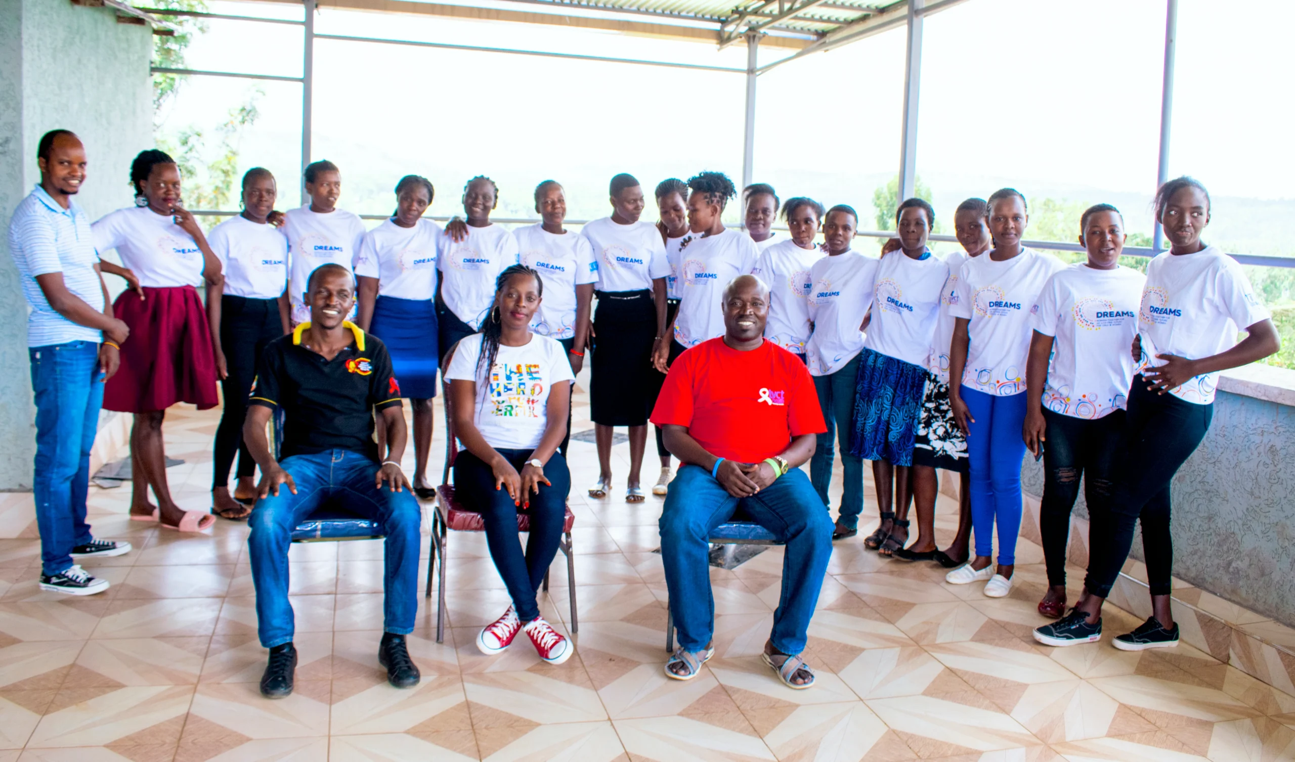 A group of people in matching shirts poses for a photo indoors, showcasing camaraderie and unity in a bright setting.